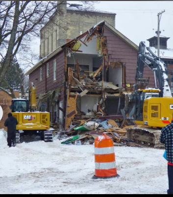 Excavators tearing down a two storey building during a winter structural demolition